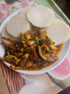 A picture of Boiling yam and fish stew with ugu.