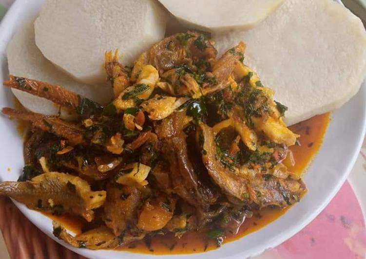 Boiling yam and fish stew with ugu