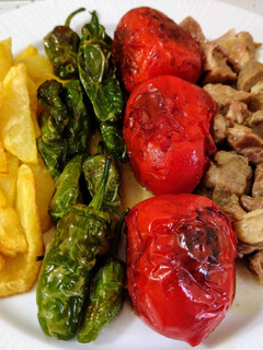 Una foto de Carne en salsa con tomates asados, patatas y pimientos fritos