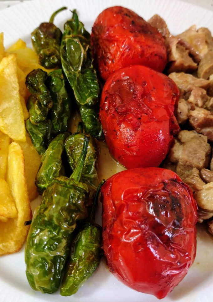 Una foto de Carne en salsa con tomates asados, patatas y pimientos fritos