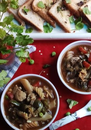 A picture of Chicken pasta with green vegetable soup.