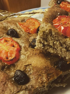 Foto di Focaccia al grano arso con pomodori e olive nere
