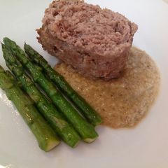 A picture of Meatloaf with prosciutto, porcini sauce and pan fried asparagus.
