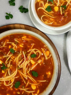 A picture of Tomato Vegetable Noodle soup.