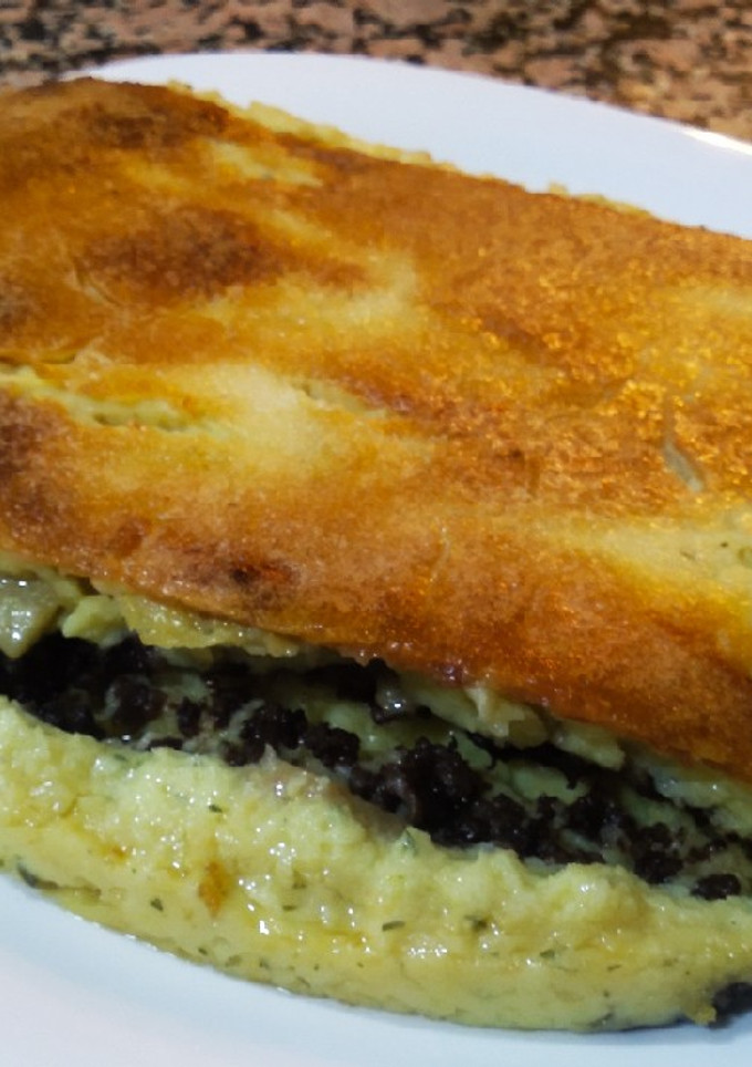 Una foto de Pastel gratinado de patata, morcilla y pera