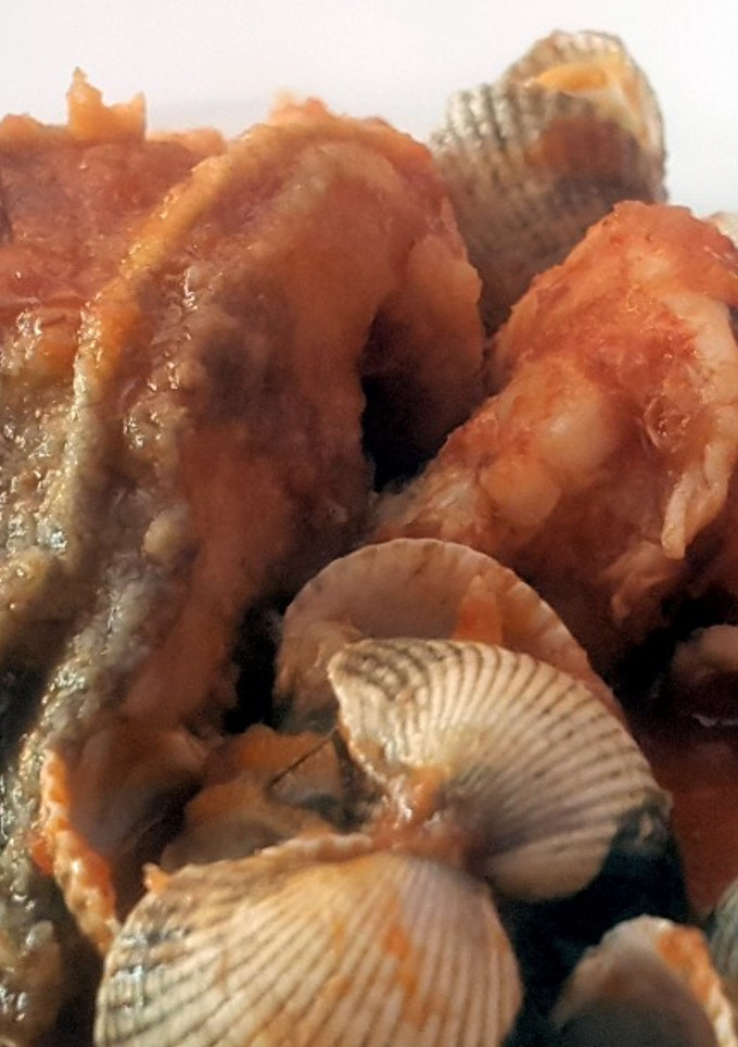 Una foto de Lubina en salsa con berberechos y gambas