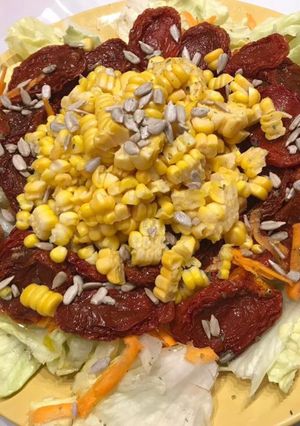 Una foto de Ensalada de tomates secos, choclo zanahoria y semillas de giraso