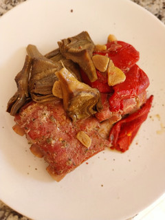 Una foto de Costillas al horno con alcachofas y pimientos del piquillo confitados