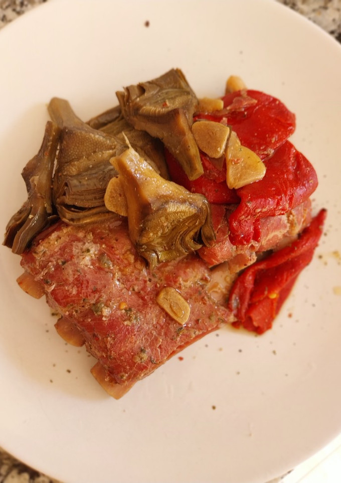 Una foto de Costillas al horno con alcachofas y pimientos del piquillo confitados