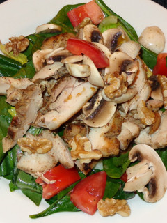 Una foto de Muslos de pollo asados con ensalada de espinaca y champiñones