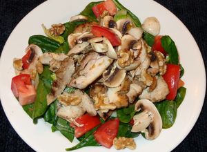 Una foto de Muslos de pollo asados con ensalada de espinaca y champiñones