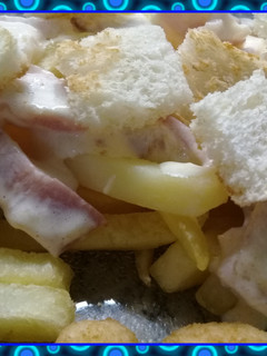 Una foto de Papas fritas con salsa y crutones