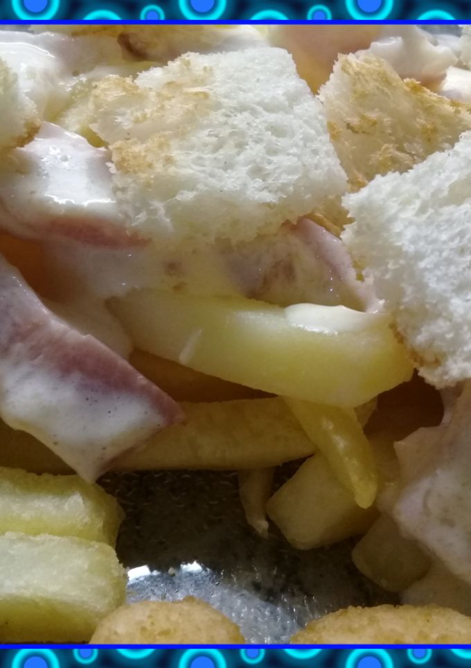 Una foto de Papas fritas con salsa y crutones