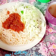 A picture of Sphagetti and vegetables with spiced tea.