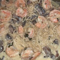 A picture of Shrimp and mushroom pasta with a basil white wine cream sauce.