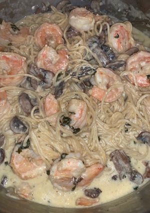 A picture of Shrimp and mushroom pasta with a basil white wine cream sauce.