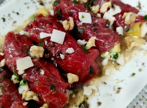 Una foto de Rollitos trufados de carpaccio con naranja y aguacate