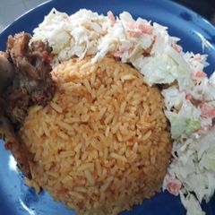 A picture of Jollof rice with coleslaw.