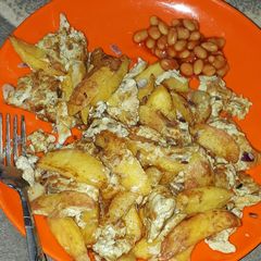 A picture of Chips and egg with baked beans.