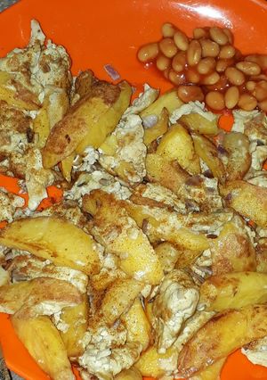 A picture of Chips and egg with baked beans.