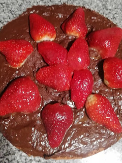 Una foto de Bizcochuelo rojo con dulce de leche, chocolate y frutillas