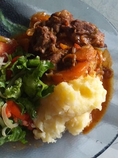 Una foto de Cazuela al vino tinto con puré de papas y ensalada