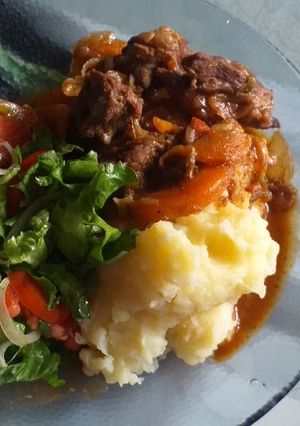 Una foto de Cazuela al vino tinto con puré de papas y ensalada