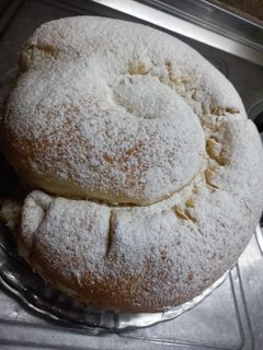 Una foto de Ensaimada de Mallorca rellena de crema pastelara y dulce de leche