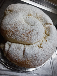 Una foto de Ensaimada de Mallorca rellena de crema pastelara y dulce de leche