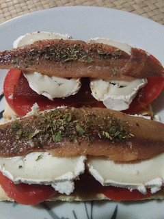 Una foto de Crackers con tomate, membrillo, rulo de cabra y anchoa
