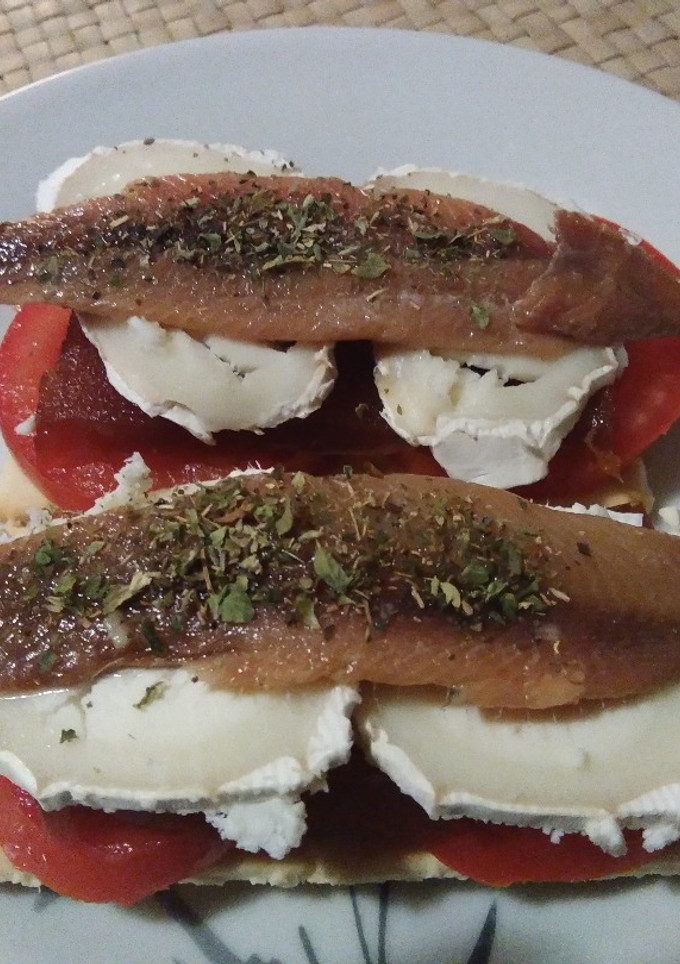 Una foto de Crackers con tomate, membrillo, rulo de cabra y anchoa