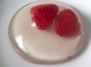 Una foto de Gota de agua al agua de rosas con frambuesas