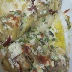 A picture of Baked potato slice with cheesy and creamy sauce.