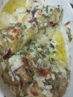 A picture of Baked potato slice with cheesy and creamy sauce.