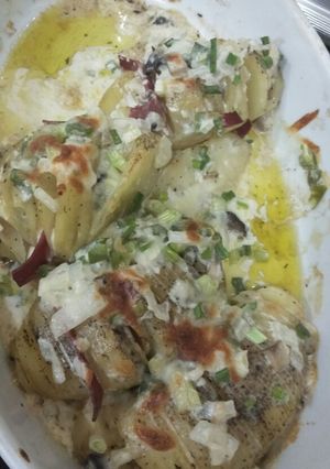 A picture of Baked potato slice with cheesy and creamy sauce.