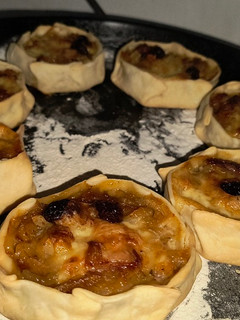 Una foto de Empanadas canastita de cebolla, panceta y pasas de uva