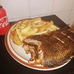 A picture of Grilled Bream fish and fried potato chips.