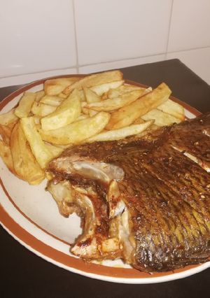 A picture of Grilled Bream fish and fried potato chips.