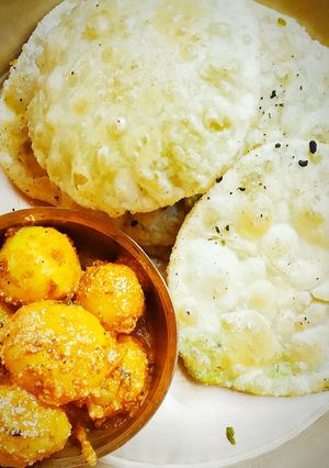 A picture of Koraisutir kochuri (Green pease kochuri) and Kashmiri aloor dum.