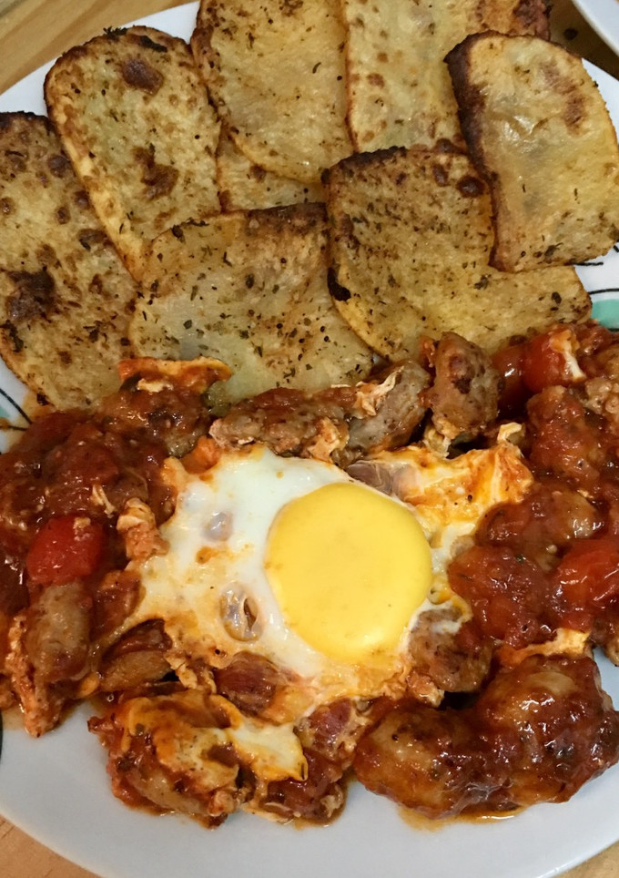 Una foto de Butifarra con salsa de tomate picante, huevos y patatas al horno