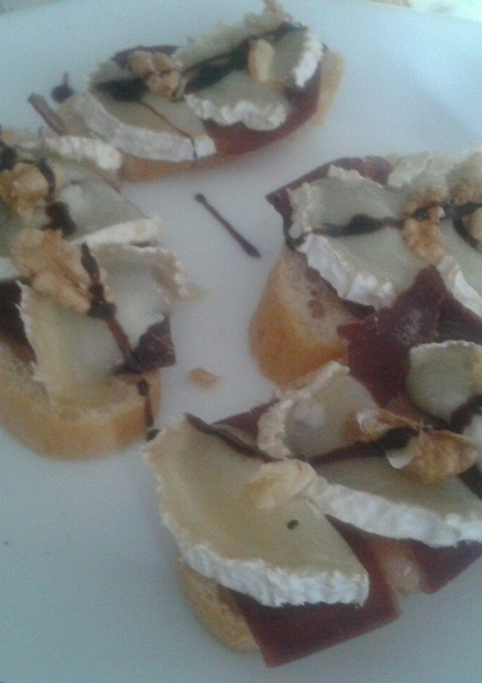 Una foto de Tosta de cecina con queso de cabra, nueces e hilo de crema de vinagre balsámico