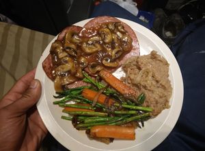 Una foto de Pierna ahumada con gravy de champiñones y espárragos acitronados a la mantequilla
