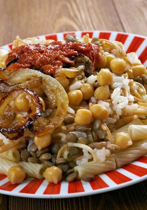 A picture of Egyptian Koshari with Tomato Sauce and Dukka.
