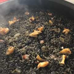 Una foto de Arroz negro de sepia, calamares y gambones