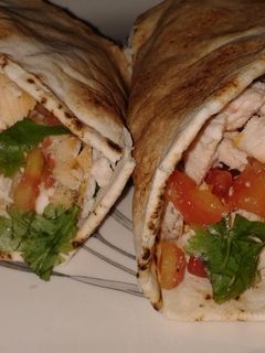 Una foto de Sandwich de pollo y vegetales con pan árabe