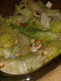 Una foto de Ensalada de lechuga, queso y almendras con aderezo de miel y mostaza