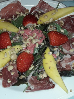 Una foto de Ensaladas variadas con mango, fresas, jamón, frutos seos y vinagreta de frambuesas