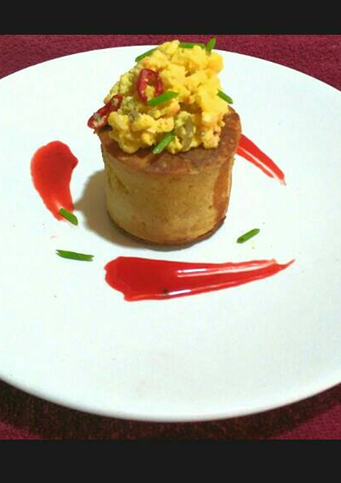 A picture of Elevated Pancake with Scrambled Buttered Eggs and Homemade Syrup.