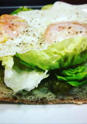Foto principal de Huevos fritos sobre chapata bañada en salsa pesto