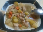 A picture of chicken soup with vegetables